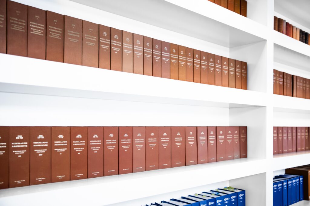 a row of brown books on white shelves